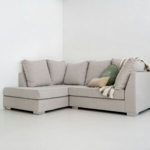 A light gray sectional sofa with pillows and blanket.